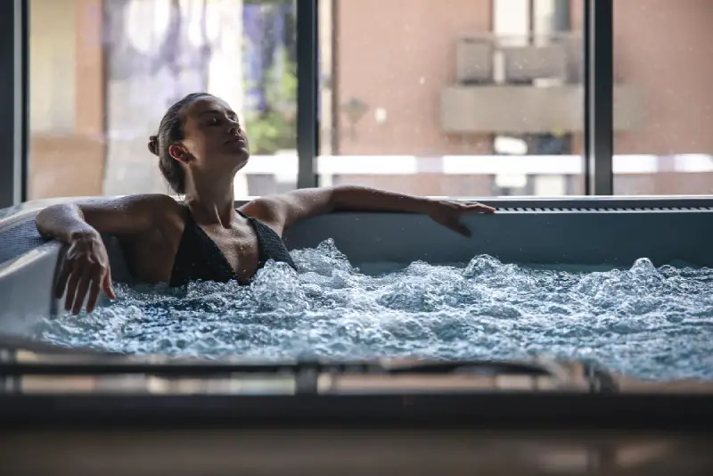 Satisfaction is Our Passion A young woman is relaxing in a jacuzzi